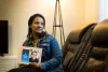 Meseret Haile displays a photo of her son Leoul. Leoul, who has special needs, is in a facility in Kansas because Washington