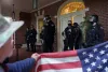 Protesters square off with law enforcement officers on the front porch of the Governor's Mansion after a group of people got