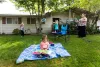As her 2-year-old Zoey enjoys a picture book, Jessica Heavner throws a Frisbee with her son Joseph, 3, and daughter Alexia,