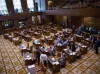 Democratic members of the Oregon Senate sit and stand around the mostly empty Senate chambers at the Oregon Capitol in