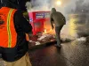 Officials douse the flames after an incendiary device was placed in a ballot box in Vancouver, Wash., in November 2024.