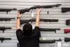 An employee puts back an Remington 870 shotgun for sale at Wade's Eastside Guns in Bellevue on Monday, Aug. 22, 2022.
