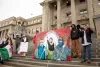 Eddie Melendrez, a Chicano artist, speaks in a megaphone while showcasing his mural representing the United Farmworkers of