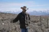 Rancher Edward Bartell stands by a fence blocking access to the Thacker Pass mine site outside of Orovada, Nevada, on March