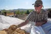 Tom McCoy, cofounder of C6 Forest to Farm, with sawmill dust that the nonprofit is using as feedstock to start up its