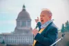 State Rep. Jim Walsh, R-Aberdeen, points to the Washington State Capitol during a 2021 rally in support of bringing back