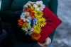 Amythist McCart shows her high school graduation cap adorned with a photo of her friend, missing teenager Kit Nelson-Mora.